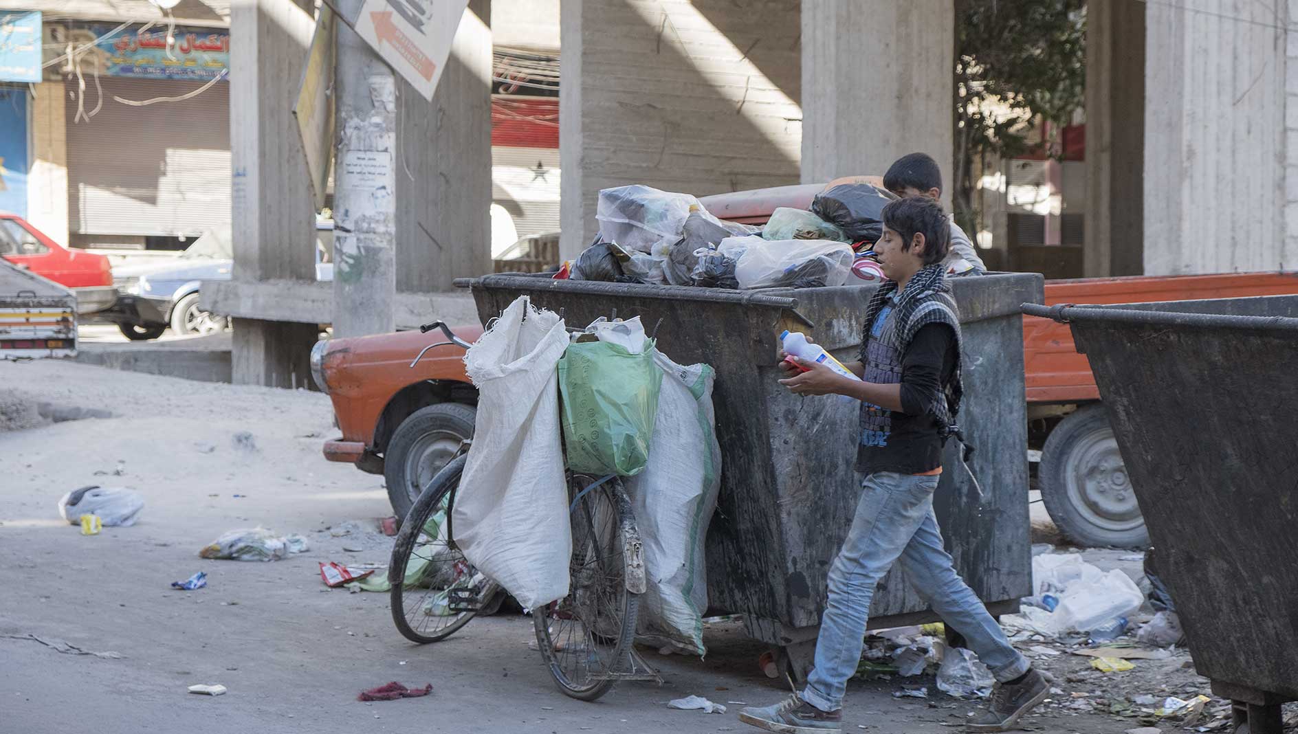 bambini in Siria che raccolgono rifuti dal cassonetto